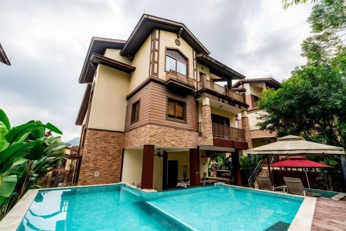 A two-story house with a swimming pool in the front yard.