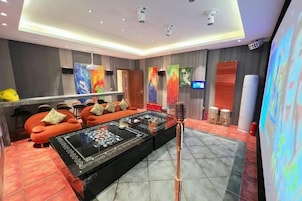 Una habitación de hotel moderna con un sofá grande, una mesa de centro y una televisión.