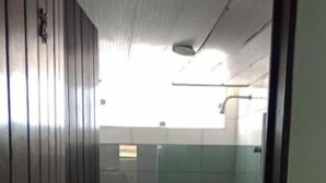 A bathroom with a toilet, a shower, and a sink.