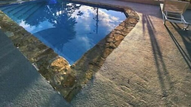 En swimmingpool med fri sikt mot himlen och bergen i bakgrunden.