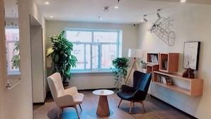 A modern interior with two chairs, a round table, and a large window. - HanTing Hotel (Yakeshi Xing'an Street) (Yakeshi)