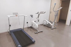 A fitness area with a treadmill, stationary bike, and elliptical machine. - HanTing Hotel (Yakeshi Xing'an Street) (Yakeshi)