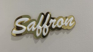 Un letrero decorativo con la palabra 'Saffron' en letras estilizadas.