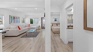Ein modernes Wohnzimmer mit einer Couch, einem Couchtisch und einem Bild an der Wand.