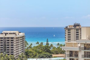 Un hôtel de grande hauteur offrant une vue sur l’océan et les palmiers.