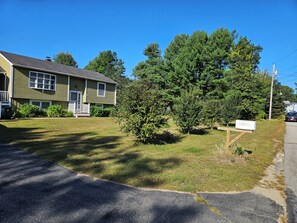 A two-story house with a front porch and a mailbox.
