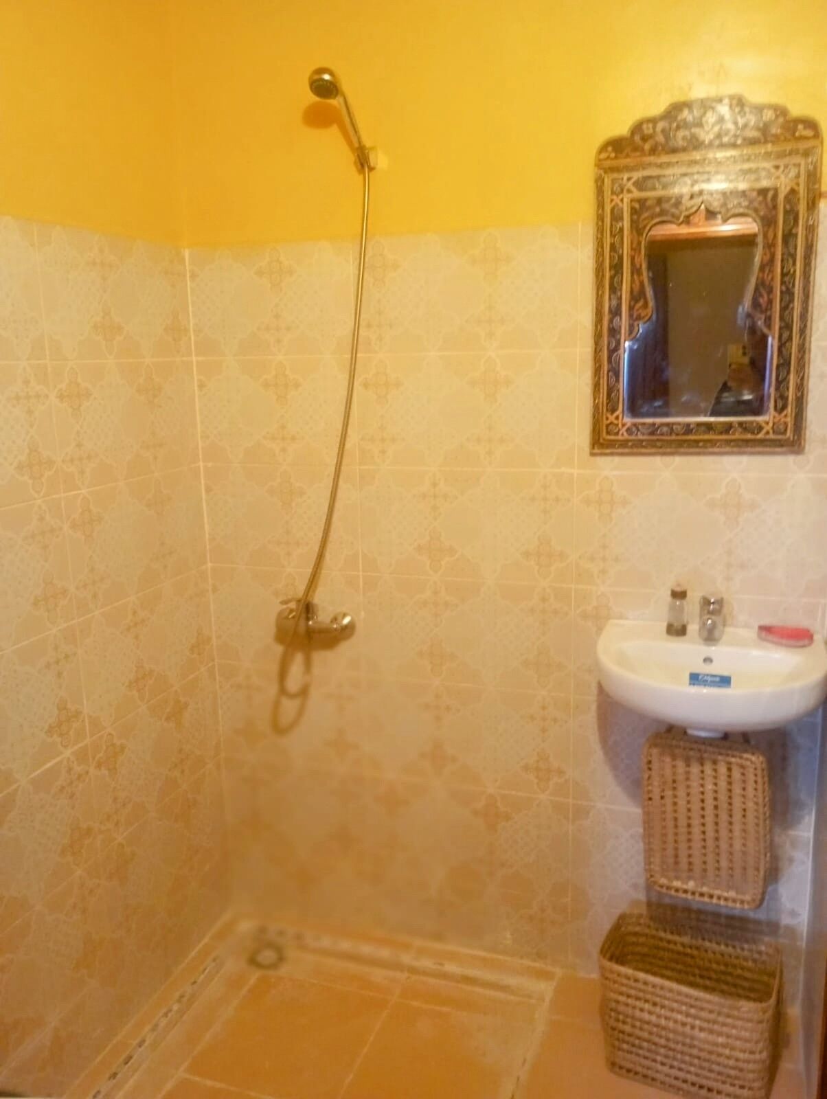 Un baño con ducha, lavabo y espejo.