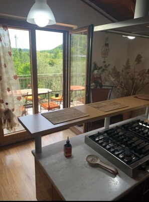 Enjoy a meal with a view from this kitchen, featuring a gas stove and a table for dining.
