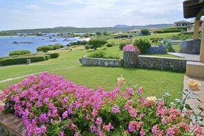 A landscaped garden with a view of a lake and mountains.