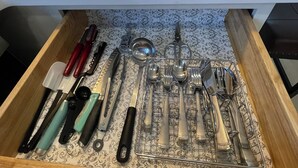 Un cajón de cocina con una variedad de utensilios de cocina ordenados.