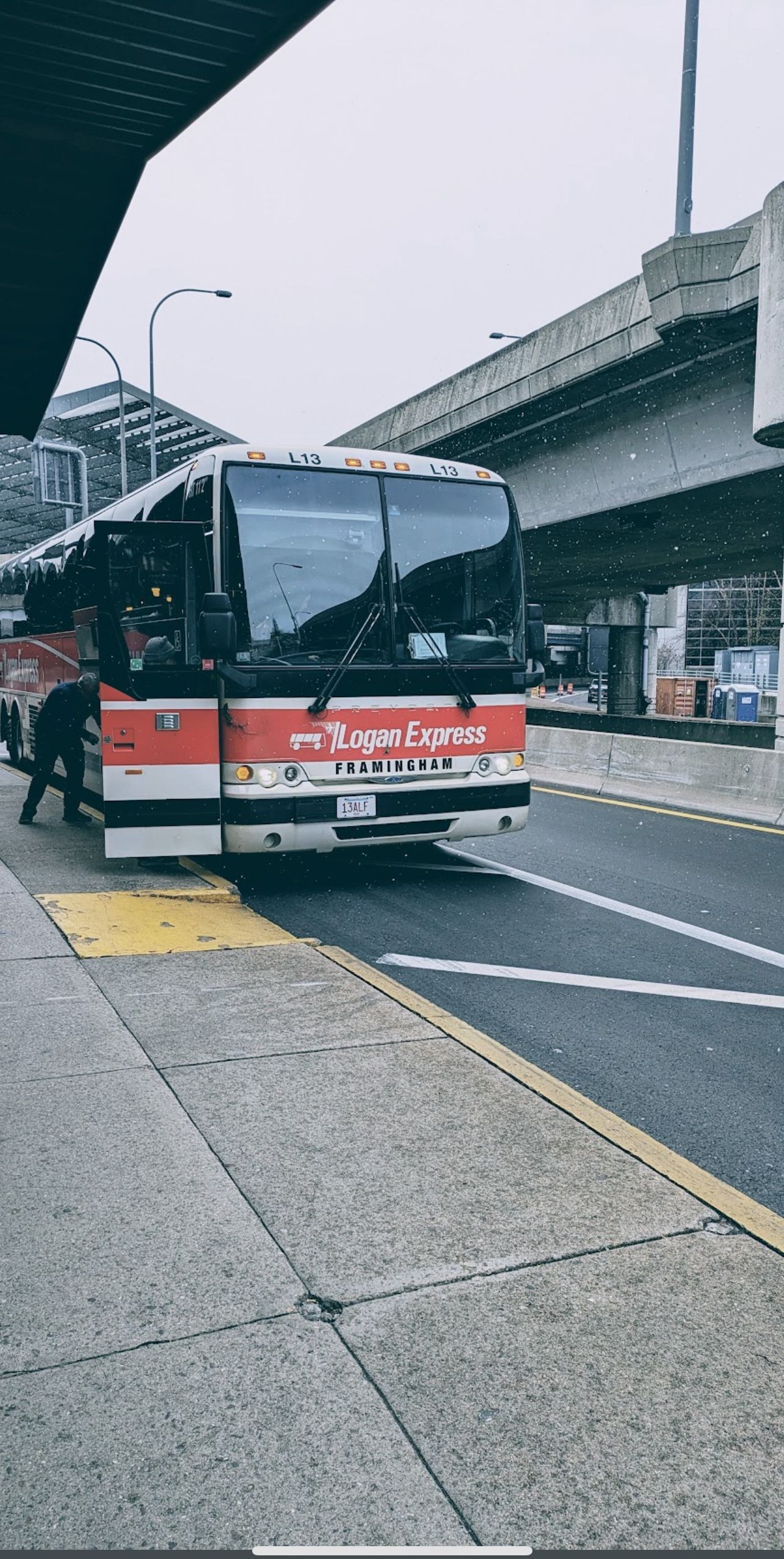 Ein Bus mit der Aufschrift 'Logan Express' an einer Bushaltestelle.