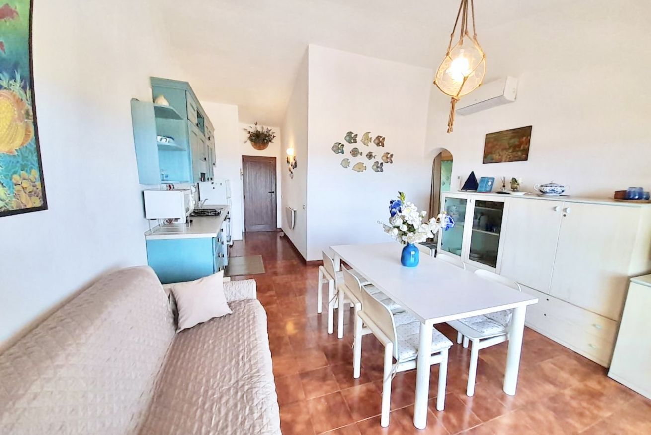 A compact living space with a dining area, kitchenette, and a sofa.