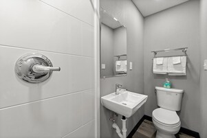 Bañera con ducha, toallas, papel higiénico