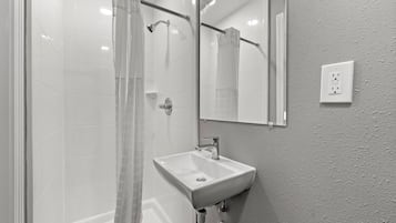 Bañera con ducha, toallas, papel higiénico