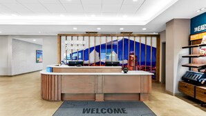 A hotel reception area with a 'Welcome to Hampton' sign, a reception desk, and a 'Welcome' mat. - Hampton Inn Daleville (Daleville)