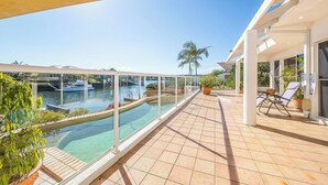 A rooftop pool with clear views of a marina and palm trees. - Spacious Canal Home With Pontoon! (BANKSIA BEACH)