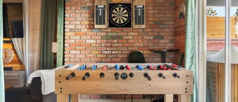 Regulation sized foosball table and darts in the back