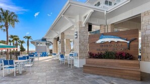 A resort with a covered outdoor seating area, a sign for 'Windsor Island Resort', and palm trees in the background. - The Fairytale Escape 5BD Pool BBQ and Resort Access (Davenport)