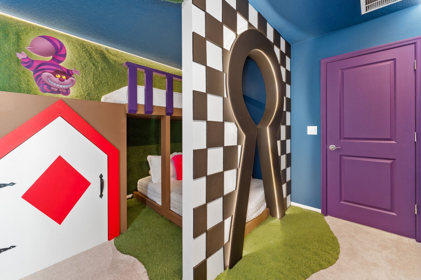A room with a bunk bed, a large decorative spoon-shaped structure, a purple door, and a wall with a cartoon character.