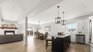 Una cocina moderna con una isla central, muebles blancos y electrodomésticos de acero inoxidable.