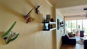 A living room with a sofa, a coffee table, and decorative wall art. - Casa Corazon Unit 702 - Ocean View, huge terrace in beautiful Puerto Vallarta! (Puerto Vallarta)