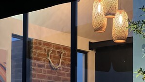 A modern interior with a brick wall, a fireplace, and a dining area with a table and chairs.