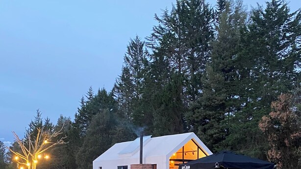 A modern house with a glass facade, a brick chimney, and a pond in the foreground. - Casa del lago en Quito, Cozy Retreat close aerport  (Quito)