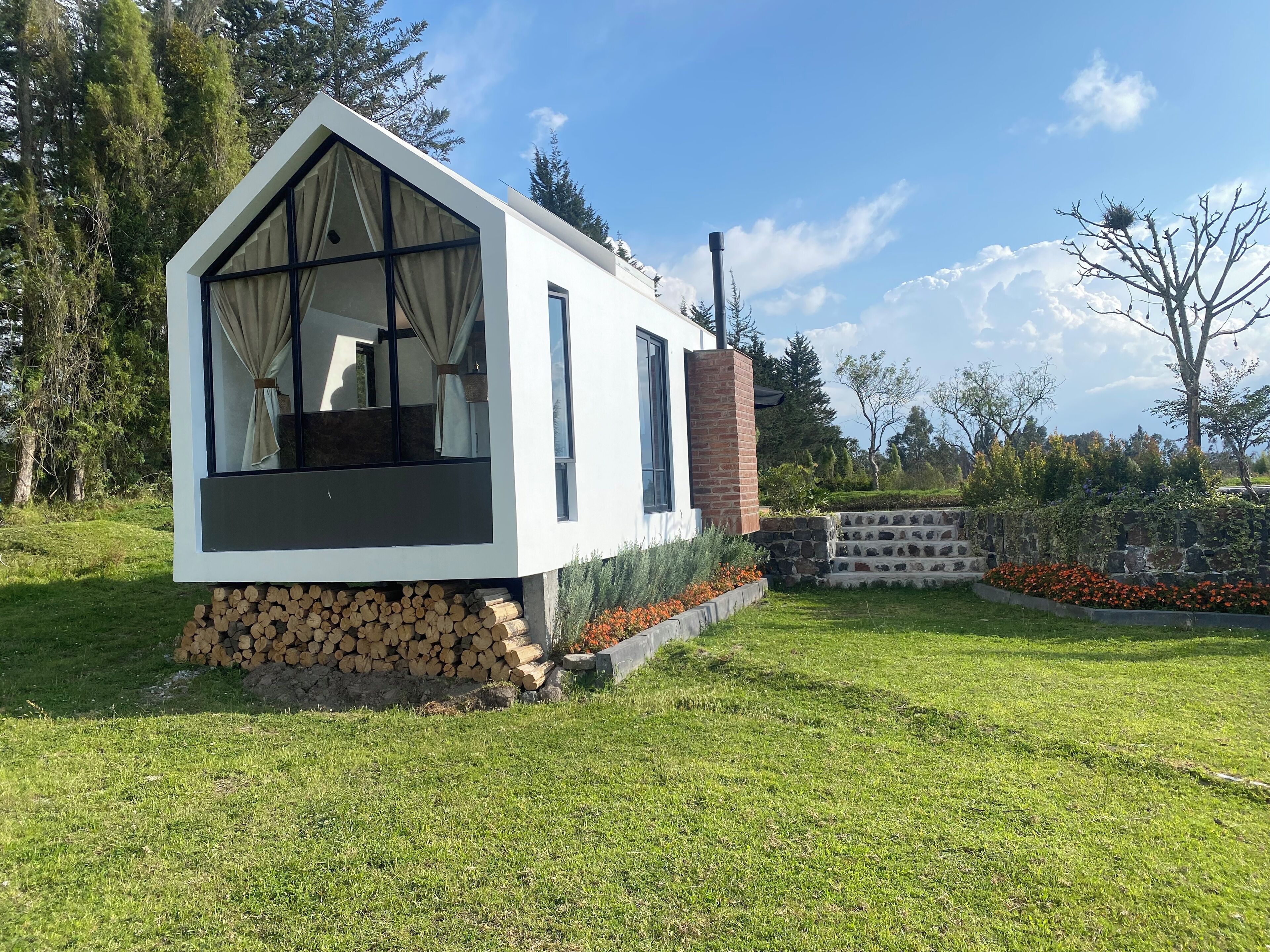Una casa moderna con un ventanal grande y una chimenea.