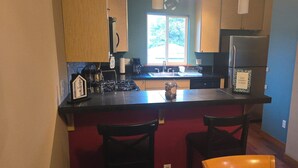 A compact kitchen with a central island, a stove, and a refrigerator. - Charming 2-bedroom townhome with WiFi, AC in enchanting Seattle (Seattle)