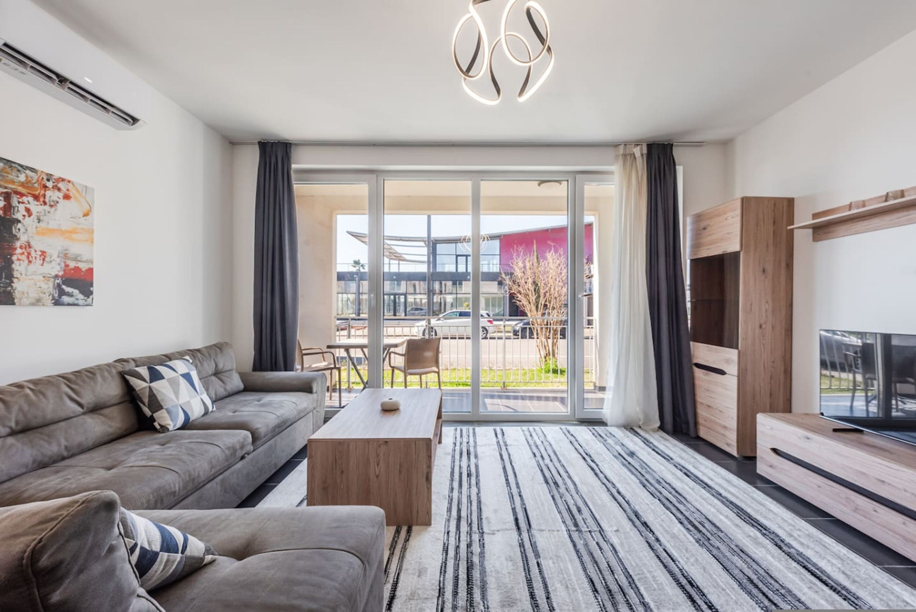 Una sala de estar moderna con sofá, mesa de centro y mueble para televisor.