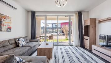 Una sala de estar moderna con sofá, mesa de centro y mueble para televisor.