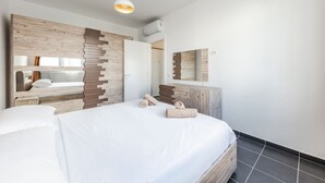 A modern bedroom with a large bed, wooden headboard, and a mirror above the dresser.