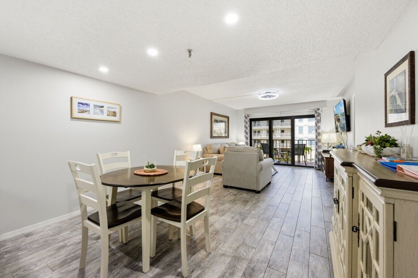 A modern apartment with a dining area, a living room, and a balcony with a view.