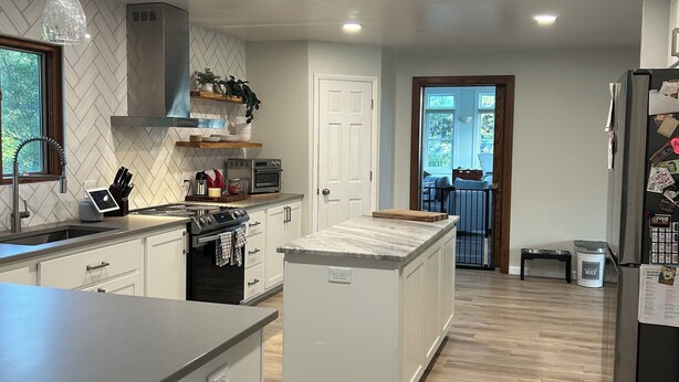 A modern kitchen with white cabinetry, a central island, and a built-in oven. - Spacious 4-bedrm, 3 bath home in FDL, new kitchen, gym, WiFi, patio, 2 tv rooms (Fond du Lac)