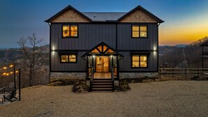 Una casa de dos pisos con fachada de madera y cimientos de piedra.
