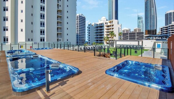 A rooftop with hot tubs and a view of tall buildings. - Hotel Room SeaView | Level 11 Walk to BeachandTram (Surfers Paradise)