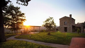 A stone building with a covered patio and a grassy lawn. - Villa Fontanine -  Poggibonsi (SI)