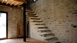 A rustic staircase with wooden steps against a stone wall, leading to a door. - Villa Fontanine -  Poggibonsi (SI)