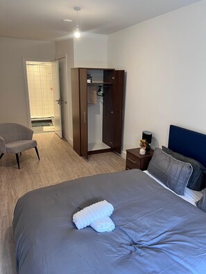 Restful retreat with a large bed, wardrobe, and bedside table.