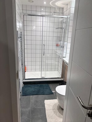 Enjoy a refreshing shower with a clear view of the bathroom's tiled walls and floor.