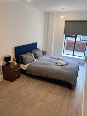 Restful retreat with a large bed, nightstand, and window offering a view.