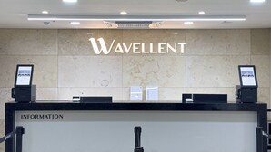 A reception desk with the name 'WAVELLENT' prominently displayed above. - Hotel Wavellent Yangyang (Yangyang)