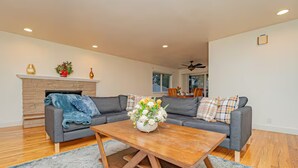 A modern living room with a fireplace, a sofa set, and a wooden coffee table.