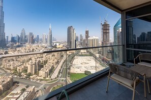 Un balcon avec vue sur la ville, comprenant des immeubles de grande hauteur et un chantier de construction.