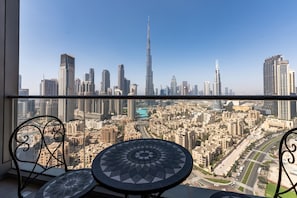 A balcony with a view of a cityscape, including a prominent skyscraper.