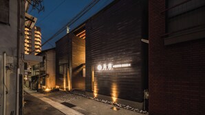 A modern building with a large garage door and a sign. - BEPPU non (Beppu)