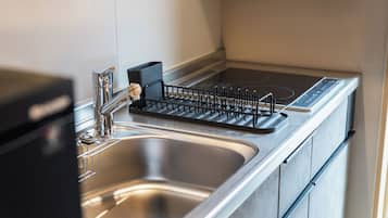 Una cocina moderna con un lavamanos de acero inoxidable, un escurreplatos negro y un horno empotrado.
