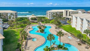 A resort with a large, winding pool surrounded by palm trees and a view of the ocean. - Gulf Front 2 Bedroom in High Pointe with Amazing Views - 35E (Inlet Beach)