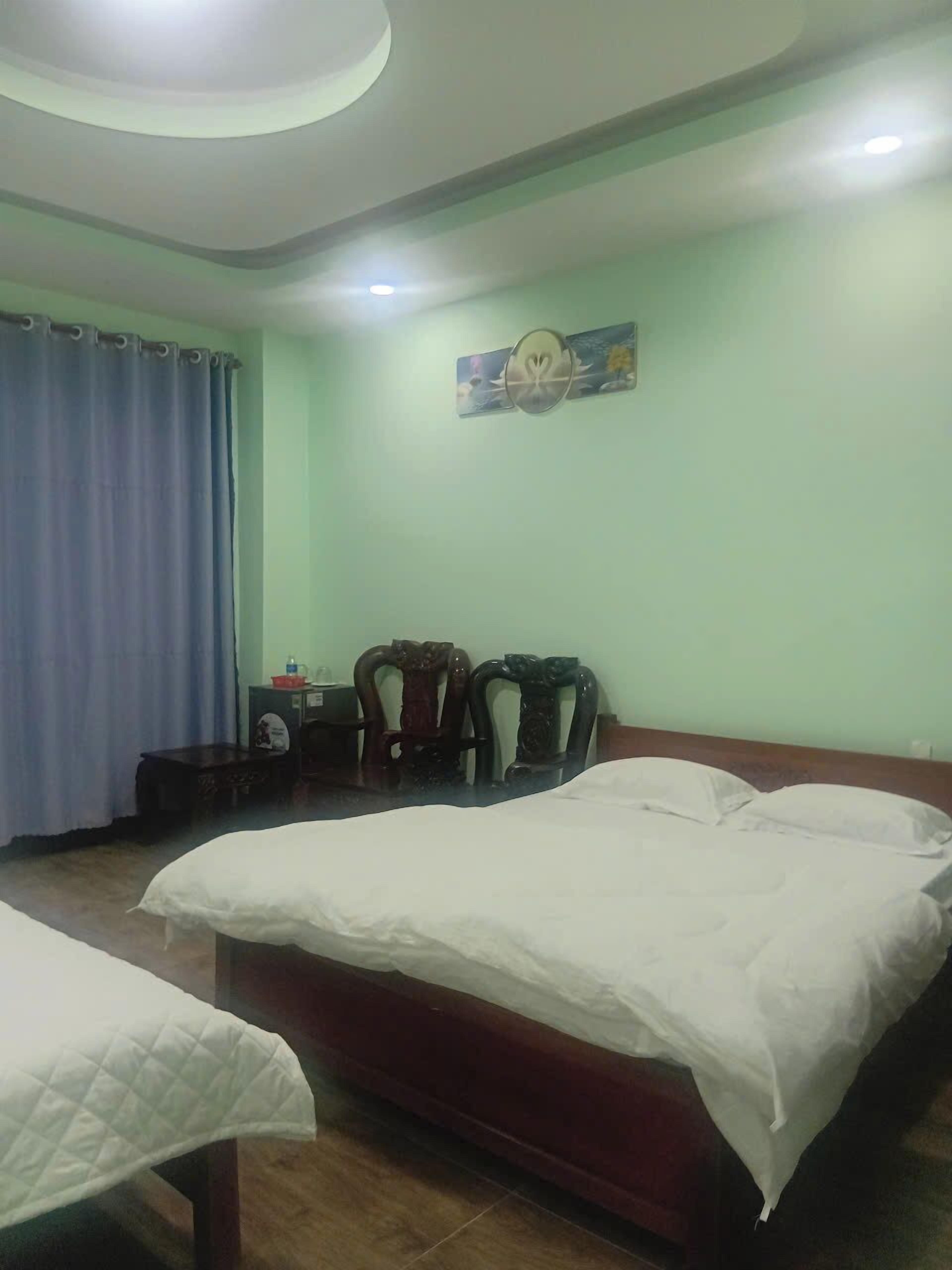 Una camera d'albergo con un letto, una sedia, una scrivania e una tenda.
