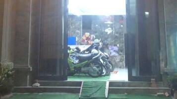 Un edificio con un letrero de neón que dice "MOTEL ĐỒNG KHÔI" y una motocicleta estacionada afuera.
